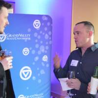 Three alumni enjoy talk with one another while enjoying their drinks